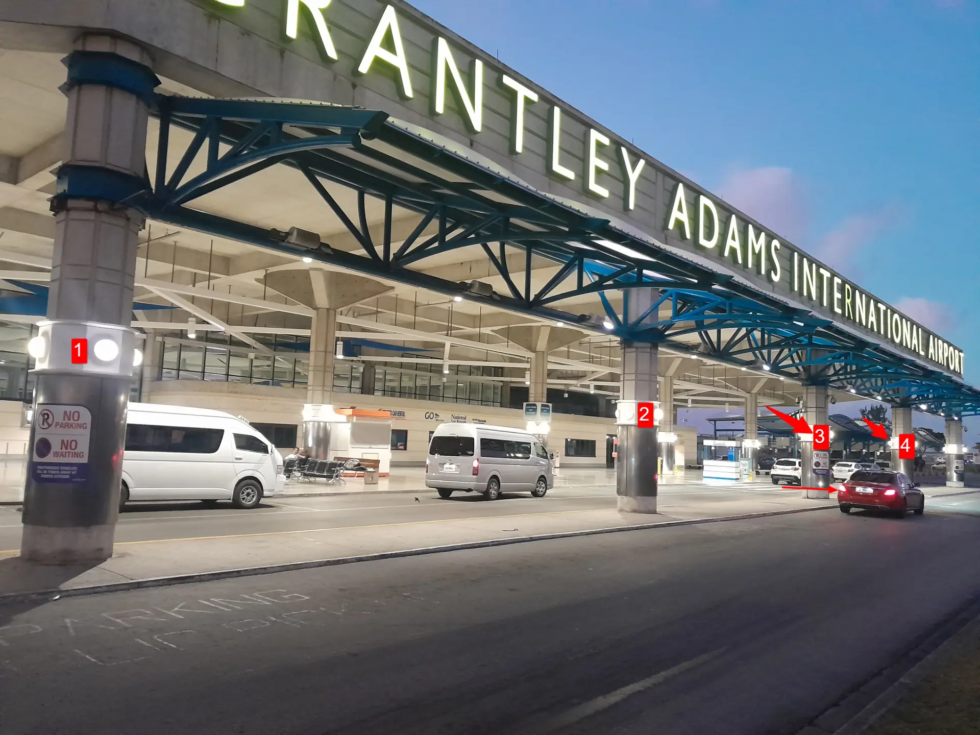 Grantley Adams International Airport curbside with the pillars numbered 1 to 4 marking the Luxe Rouge pickup point